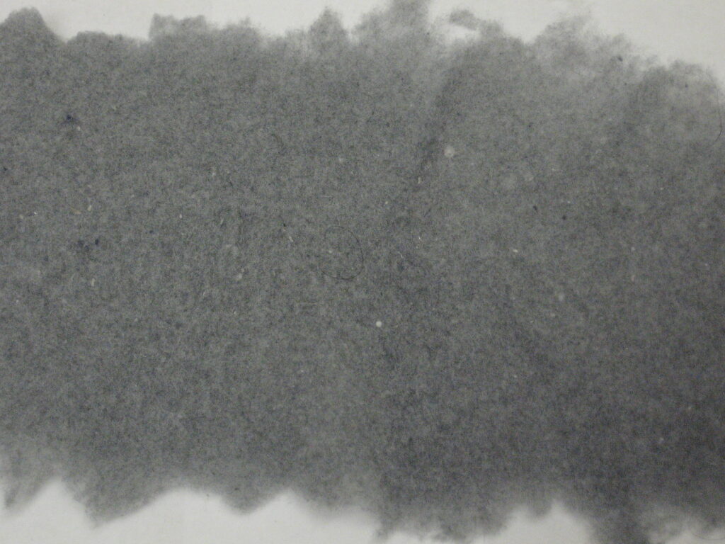 A close-up texture of a dark gray, fibrous material.