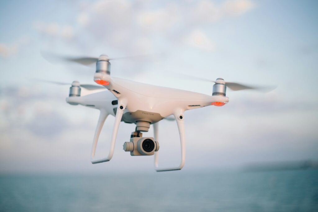 Close up photography of drone flying over body of water at daytime.