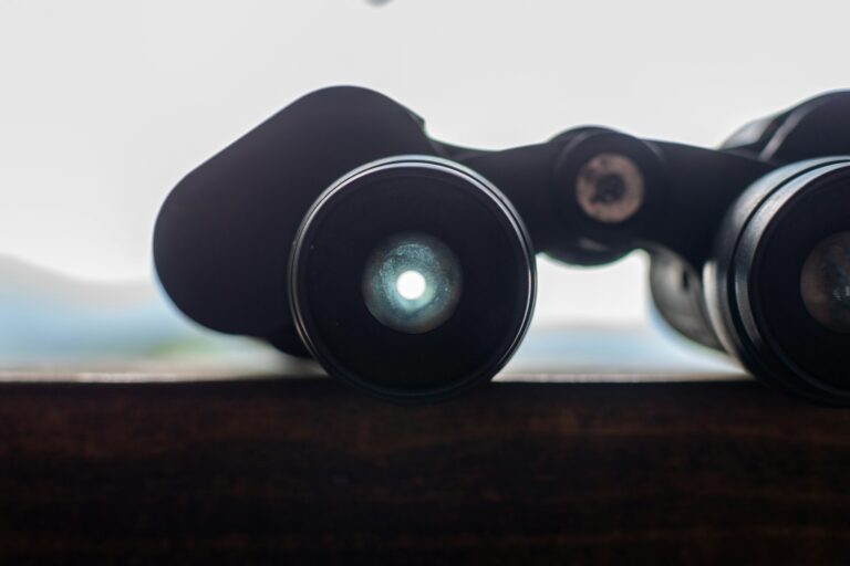 A pair of black Oberwerk Mariner 8x40 binoculars rests on a surface, showing the lens reflection.