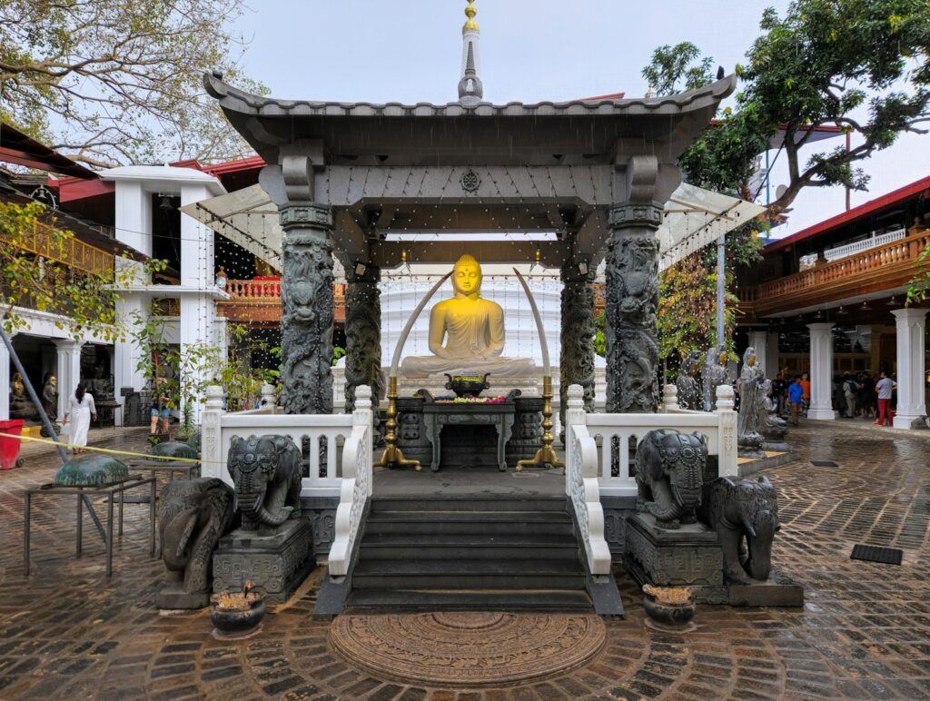 A golden buddha statue is in a shrine.