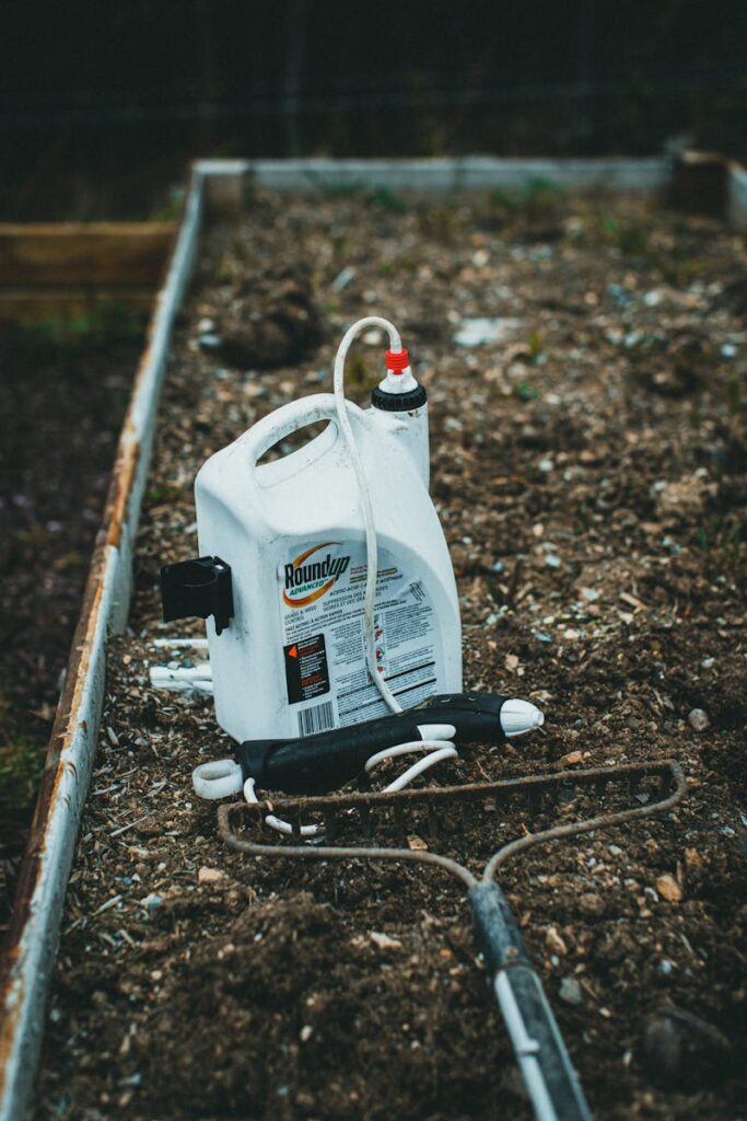 Pesticide container placed on garden soil in backyard setting