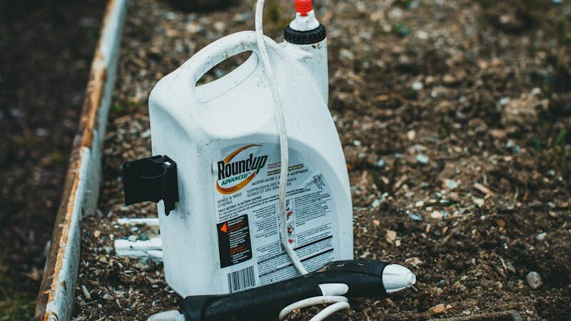 Pesticide container placed on garden soil in backyard setting
