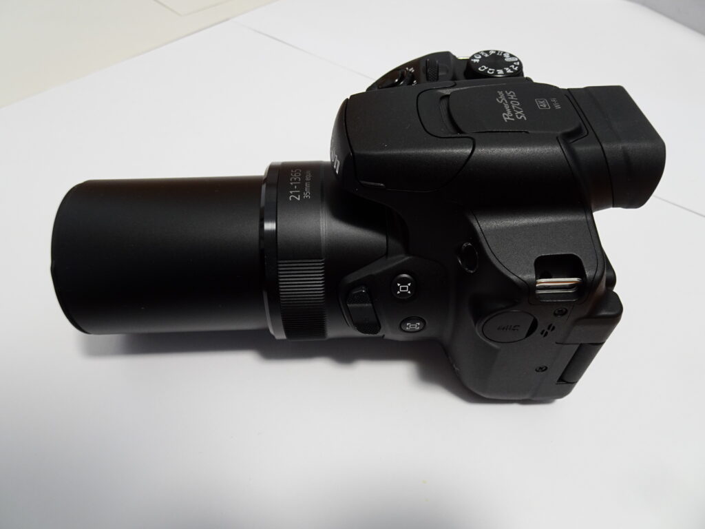 A black Canon PowerShot SX70 HS camera with a long lens.