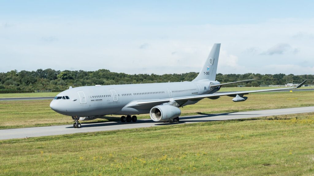A large jet aircraft taxiing on the runway at Hamburg airport on a clear day.