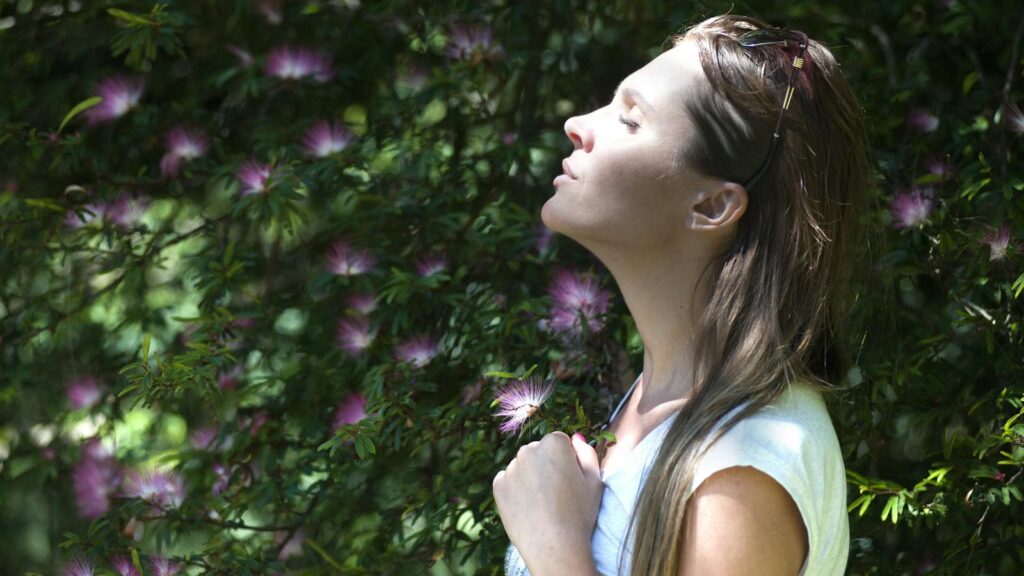 Relaxed woman surrounded by greenery, soaking in natural surroundings