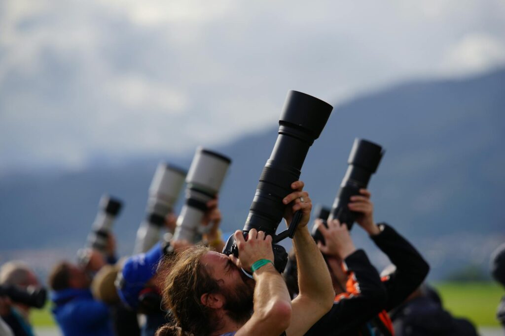 Group of photographers in Spielberg, Austria capturing planes with long lenses.