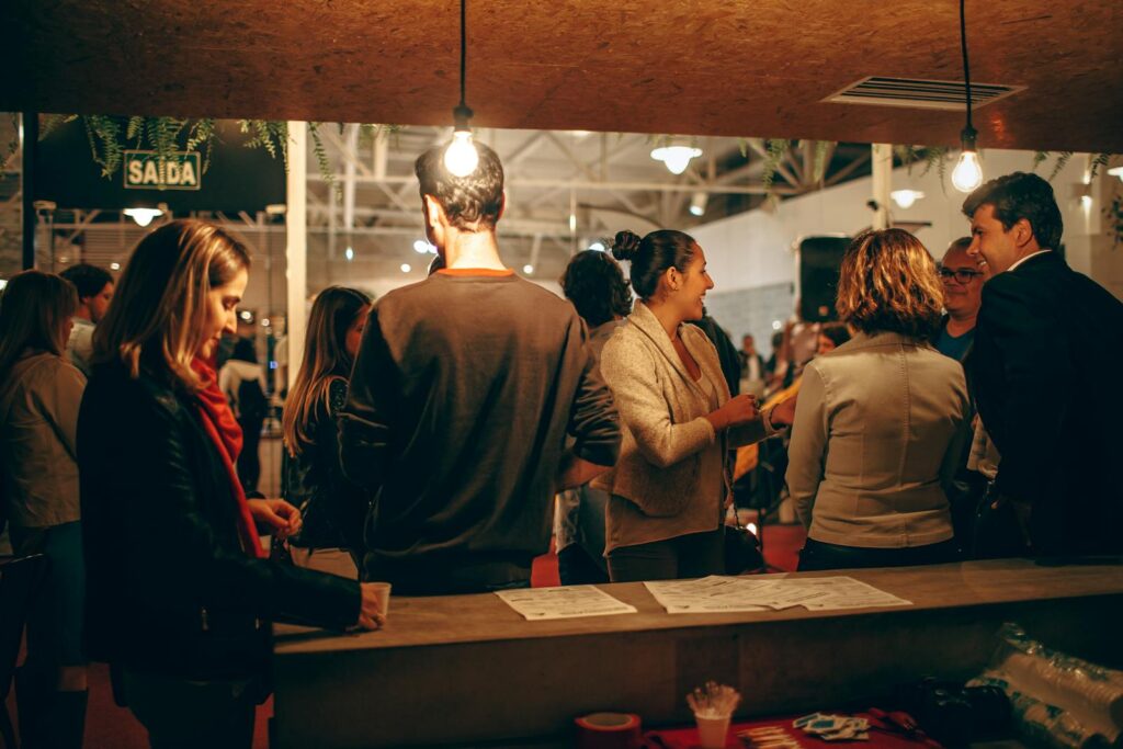A lively indoor social gathering with people interacting warmly under cozy lighting.