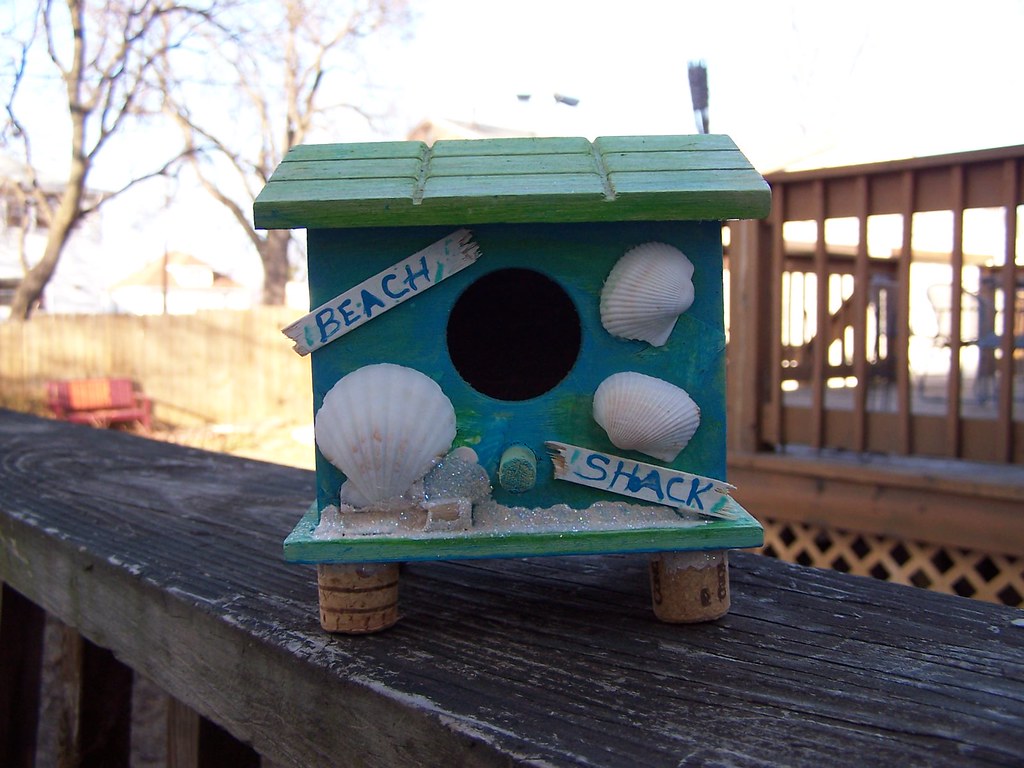 A beach-themed birdhouse with shells.