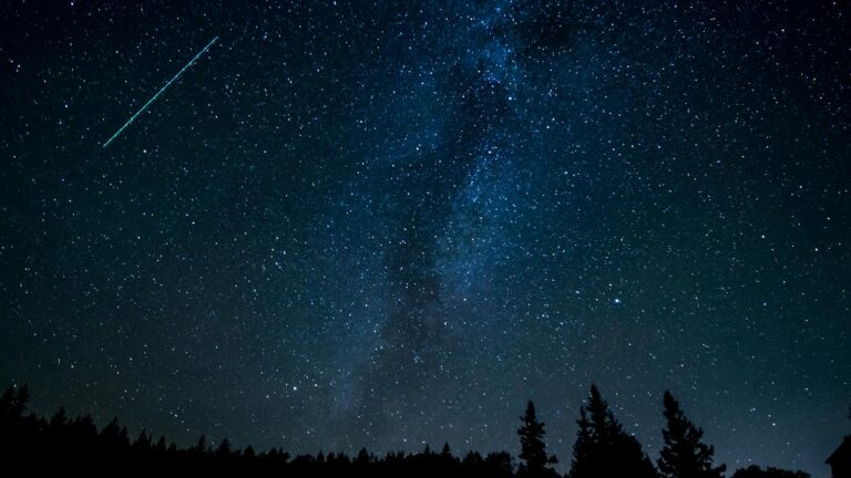 Starry night sky with a shooting star streaking across the dark sky