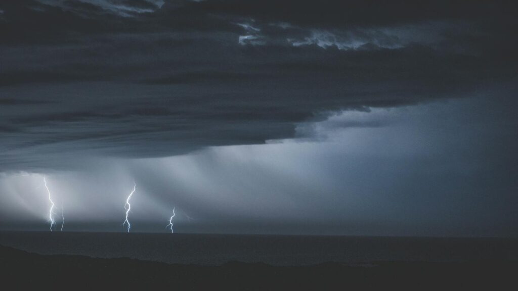 Stormy sky with dark clouds and thunder over the ocean
