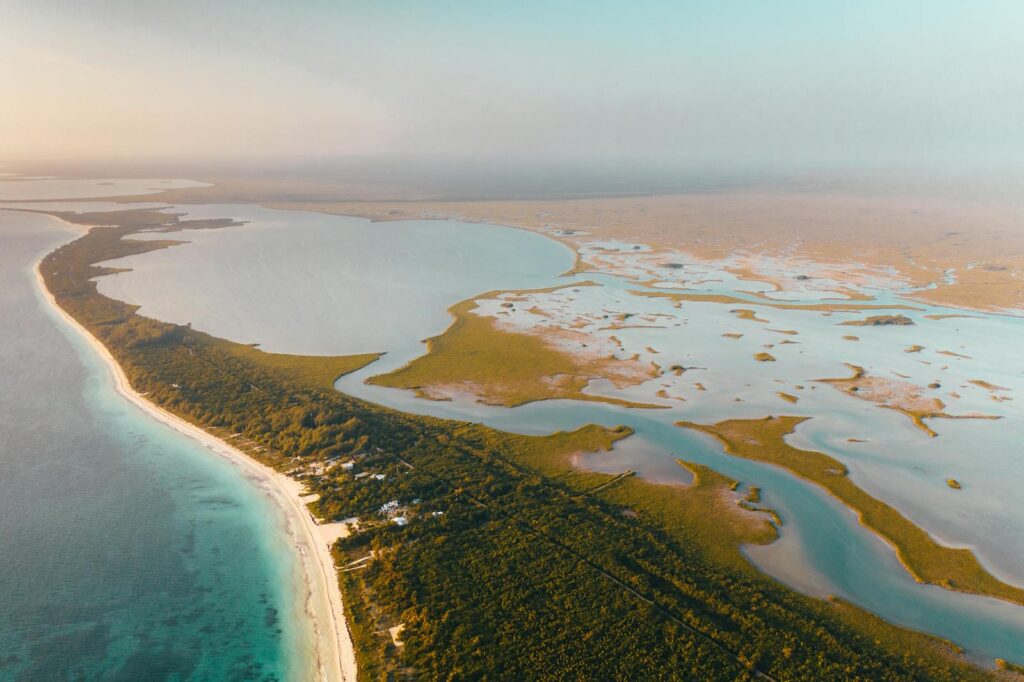 A breathtaking aerial panorama of a pristine coastal peninsula with lush greenery and blue waters.