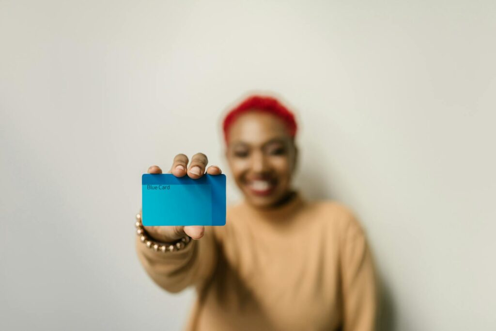 A cheerful woman with red hair displays a membership card.
