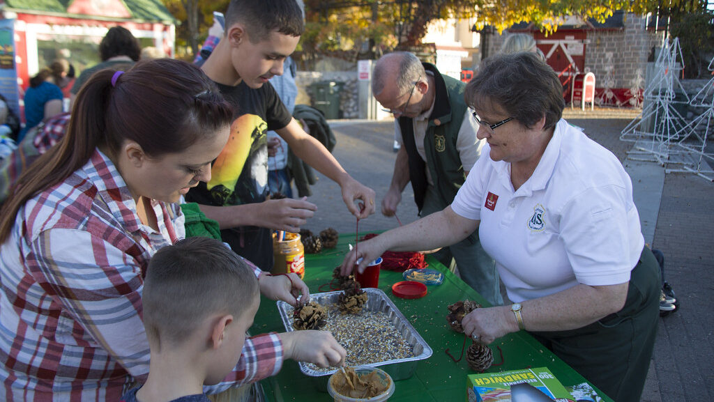 Community gathering to make homemade pine cone bird feeders