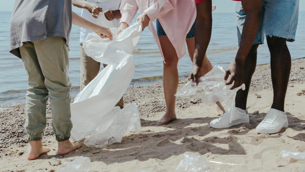 Group of volunteers cleaning up plastic on a sandy beach