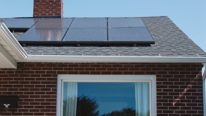 Residential brown brick home with solar panels installed on roof