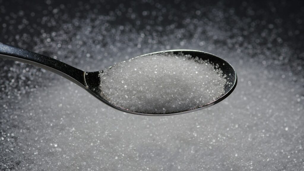 Spoon filled with white granulated sugar