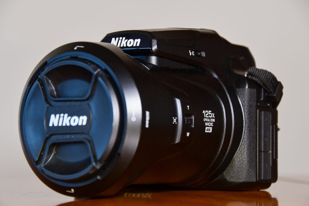 A black Nikon Coolpix P1000 camera with a large lens.