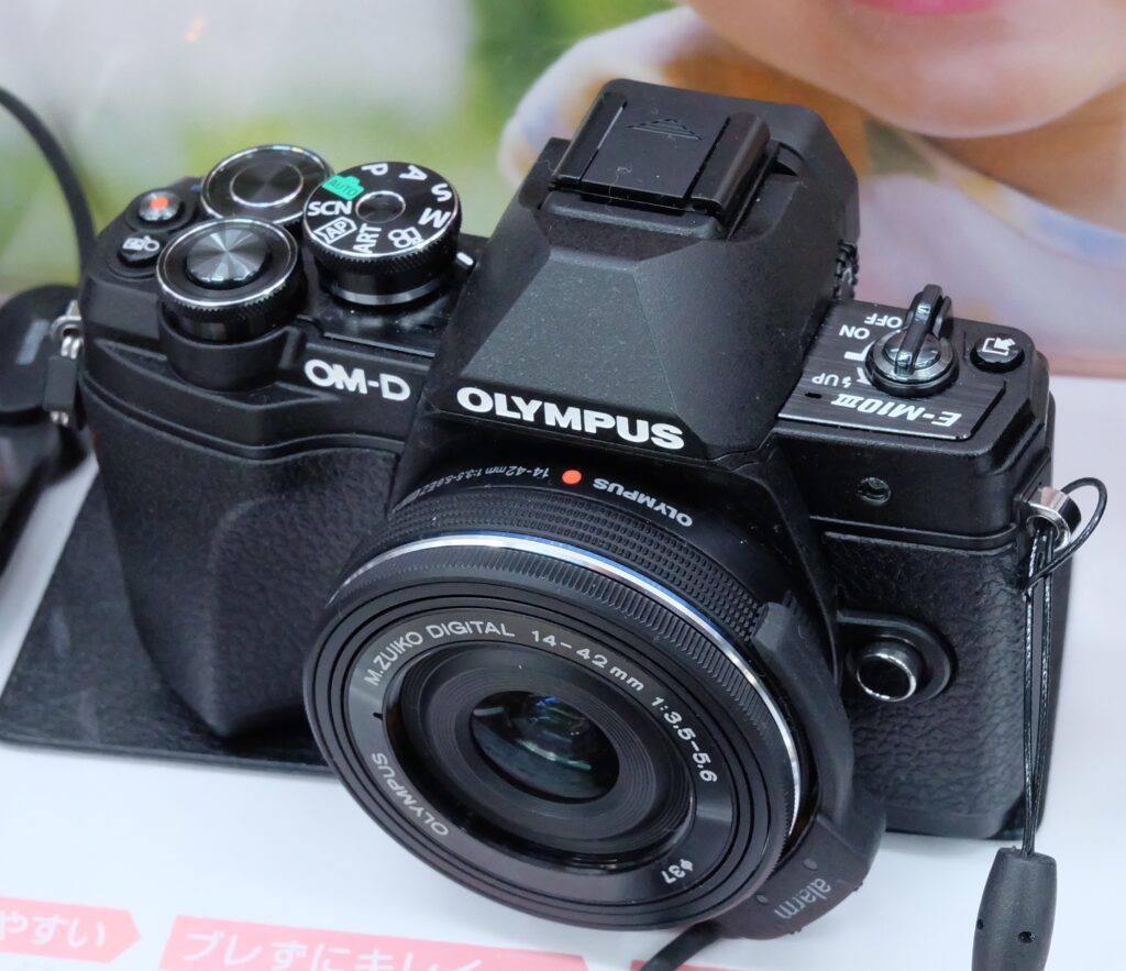 An Olympus OM-D E-M10 Mark III camera with a lens.