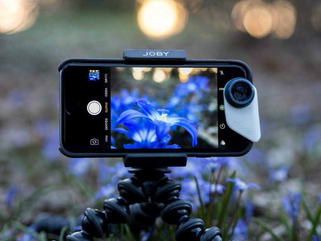 A black Android smartphone capturing blue flower.