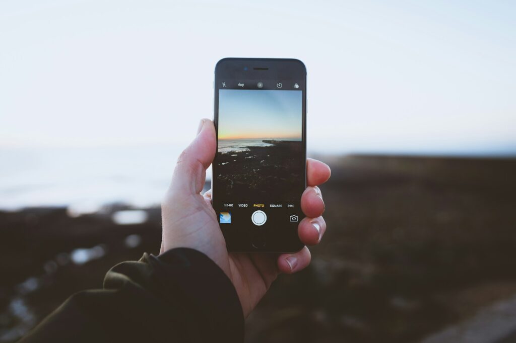 A person taking a bird photo of landscapes using iPhone during the day. 