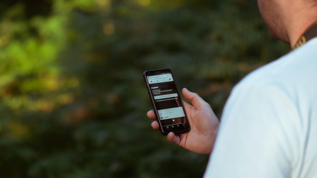 person checking phone while standing outdoors