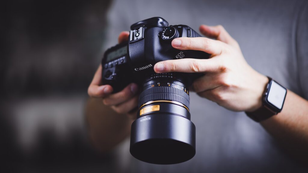 Person holding a Canon DSLR camera checking photos
