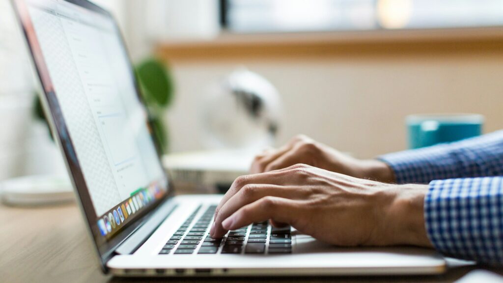 Person typing on laptop sharing information online