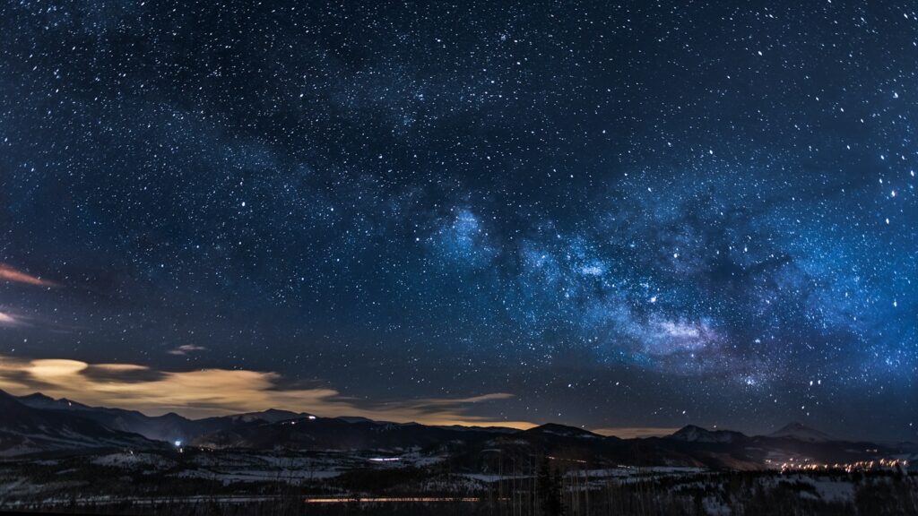 Star-filled night sky overlooking mountains