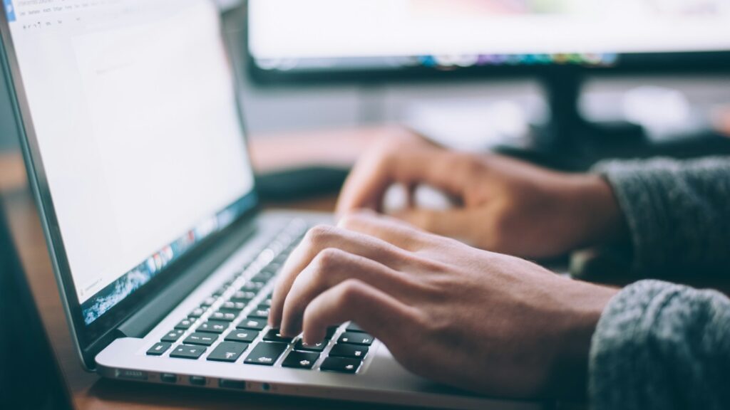 A person researches something on a laptop.
