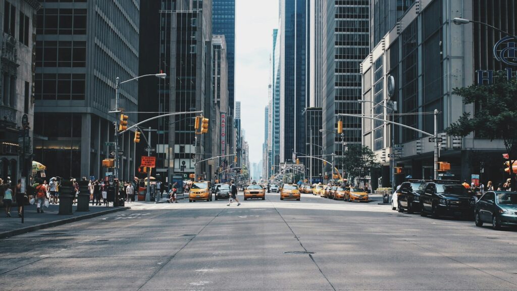 Cityscape showing road with vehicles and buildings on both sides