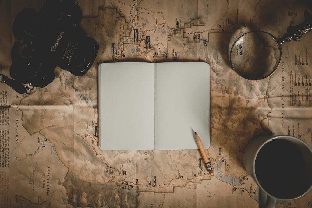 An open bird logbook on a map with a pencil.