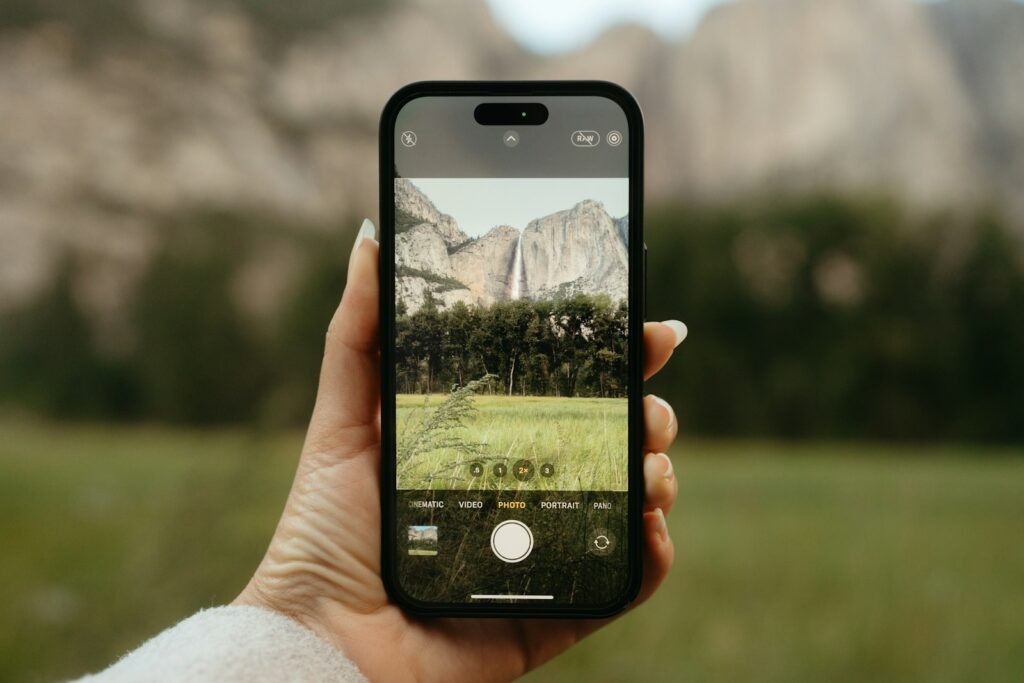 A person holding a cell phone in their hand to search for a bird.