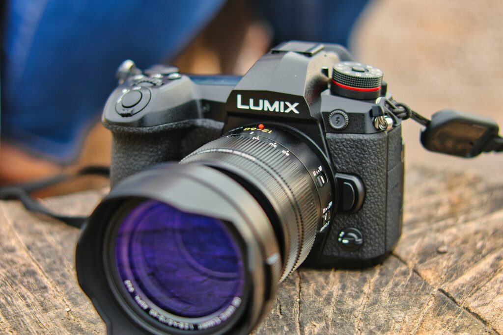 A black Panasonic Lumix FZ80 camera with a lens is placed on a wooden surface.
