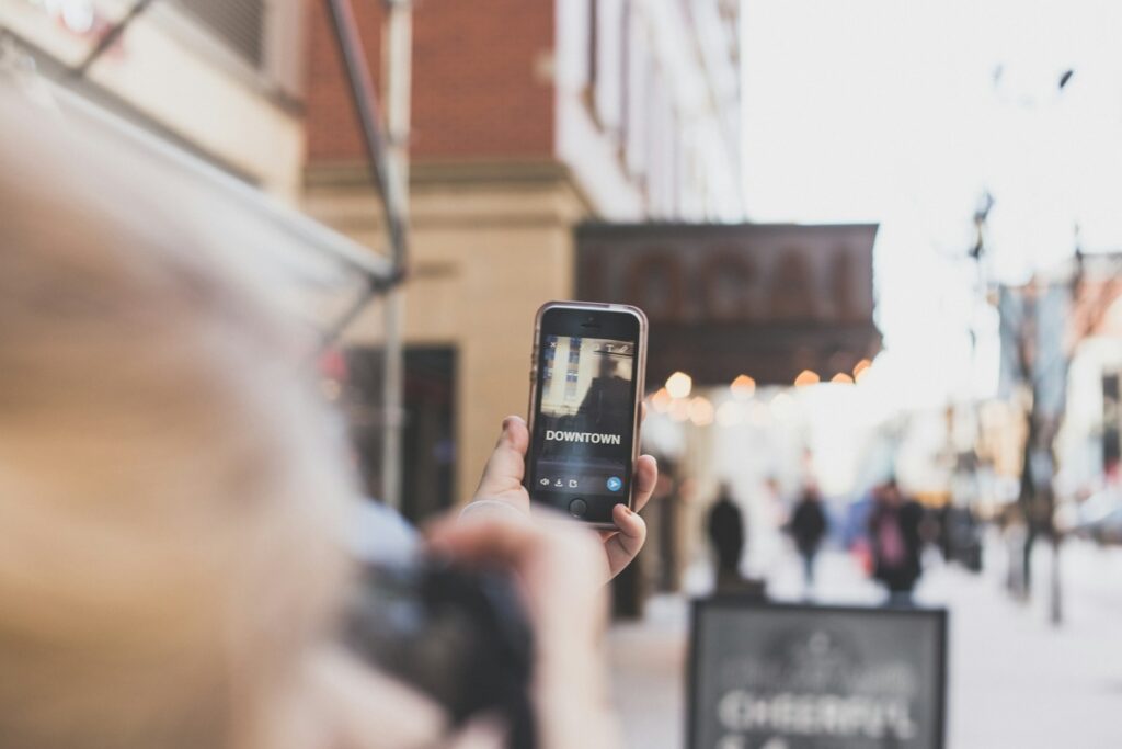 A person holds a smartphone to take a photo.