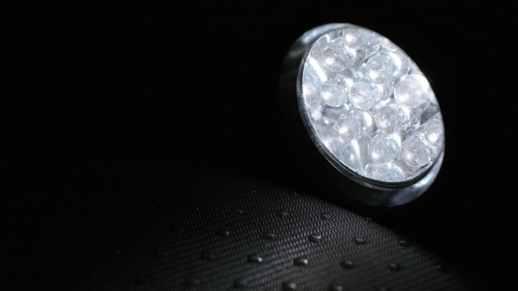 Open flashlight resting on a black rubber mat