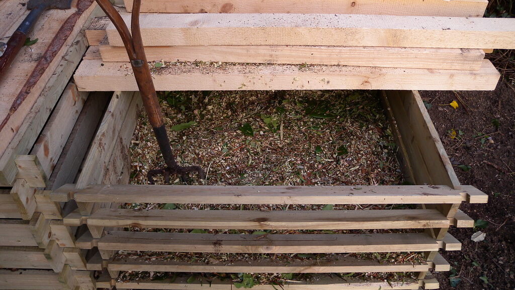 Composting box filled with shredded leaves and garden waste