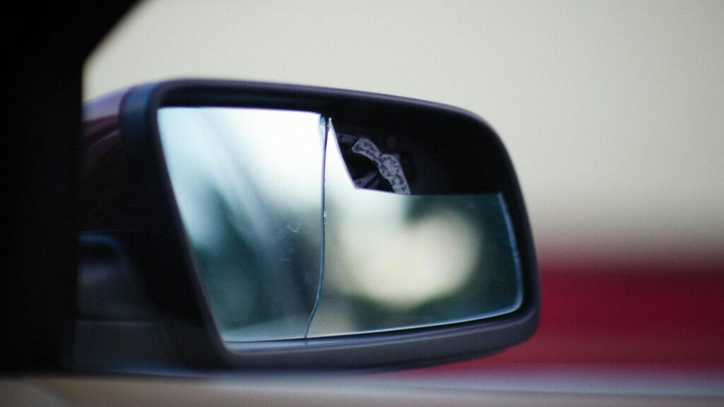 Close-up of a cracked and broken side view mirror