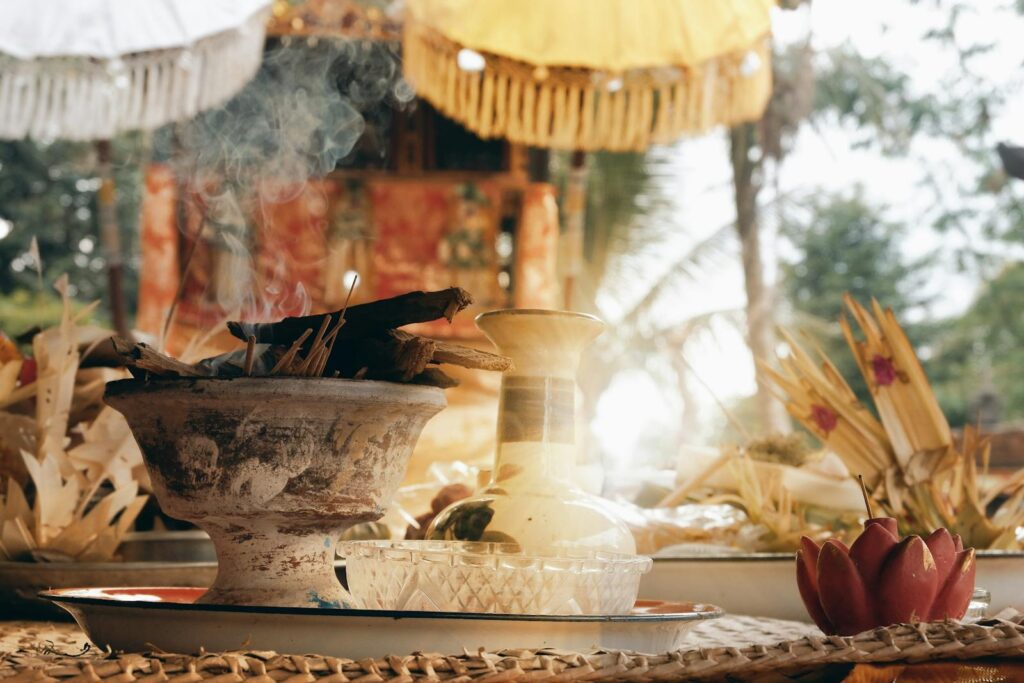 Balinese offering ritual with incense smoke, showcasing cultural decorations and atmosphere.