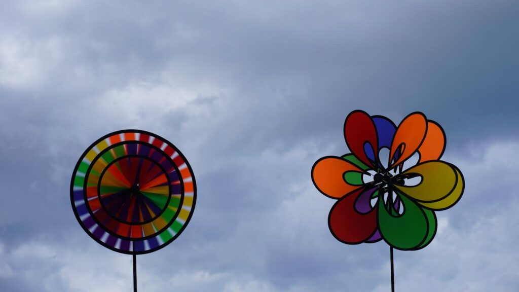 Colorful pinwheels spinning against cloudy sky