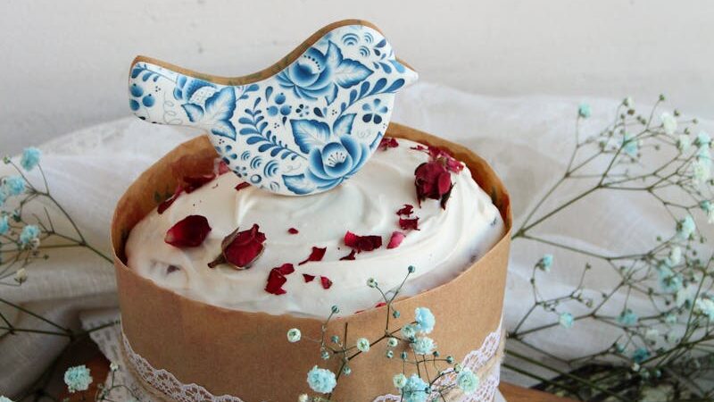 A beautifully decorated cake with a bird-shaped topper