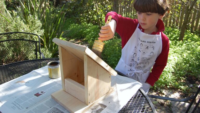 Child painting DIY wooden bird feeder