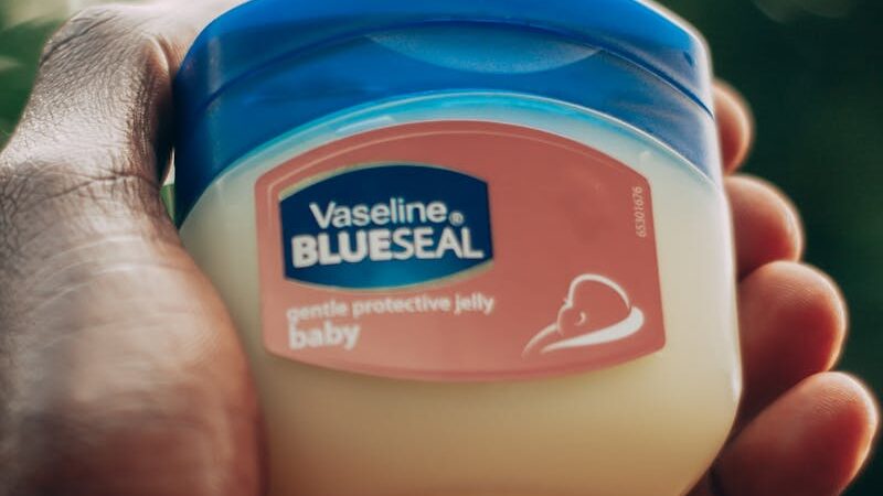 A close-up of a hand holding a jar of Vaseline.