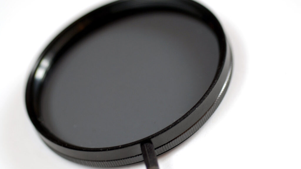 Circular polarizing camera filter placed flat on a white surface