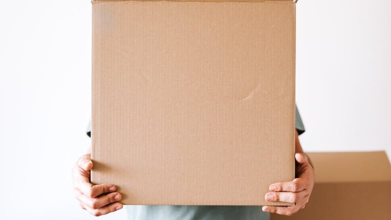 Person holding an open cardboard box