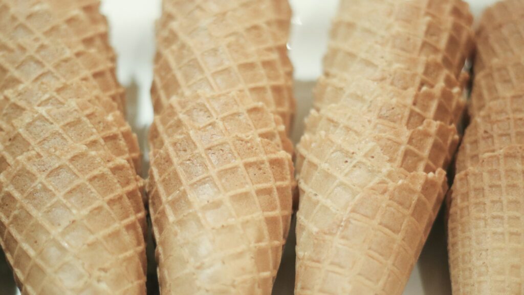 Stacks of empty ice cream cones on clean white surface