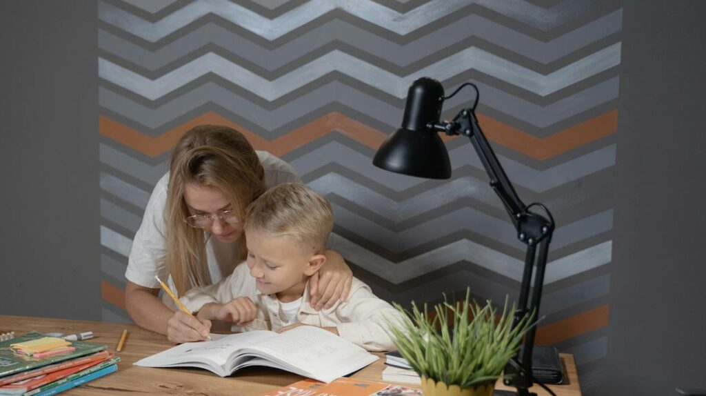 Mother helping her son write in a personal journal
