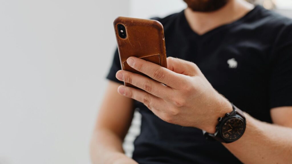Hands of person dialing on mobile phone