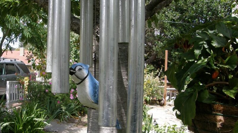 Decorative wind chime featuring a blue bird ornament in the center