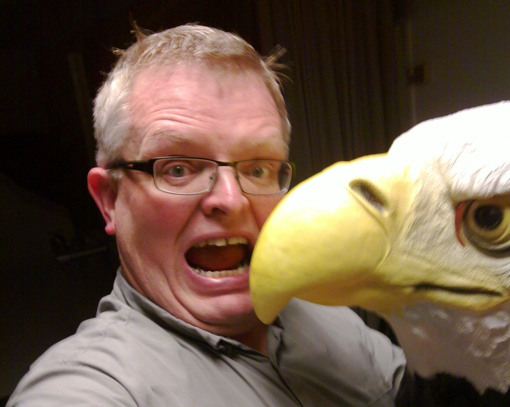 A person reacts dramatically as the beak of a Terror Bird approaches their open mouth.
