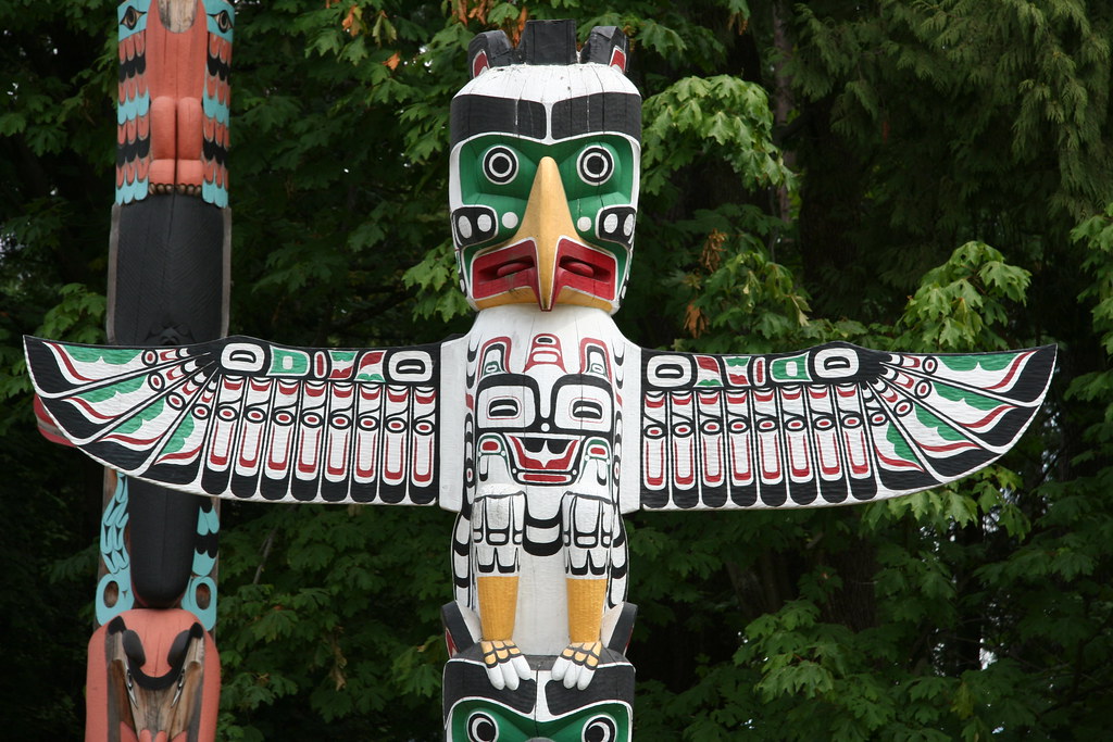 A brightly painted totem pole features a stylized Thunderbird figure with outstretched wings.